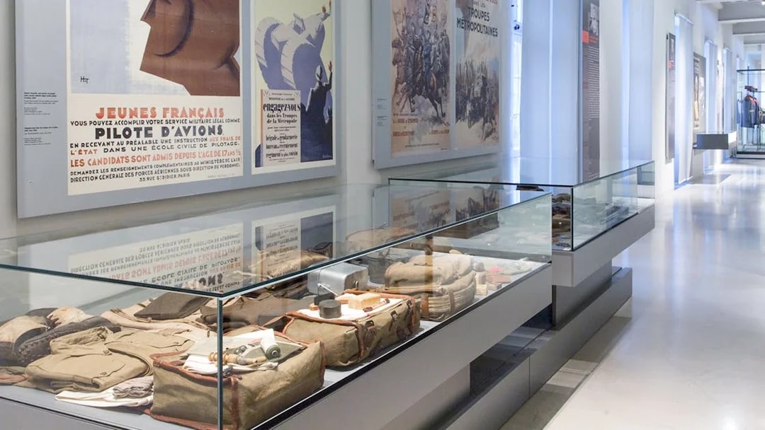 Display of military artifacts and vintage posters at Paris Army Museum exhibition.