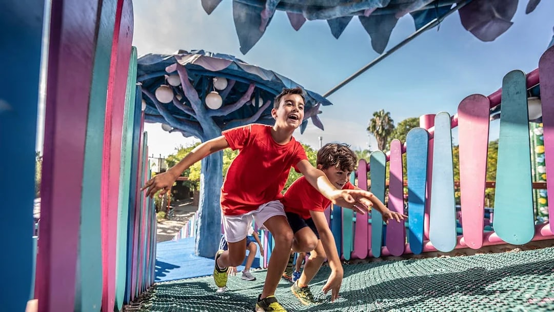 Children playing on a colorful playground at Isla Mágica, Seville.