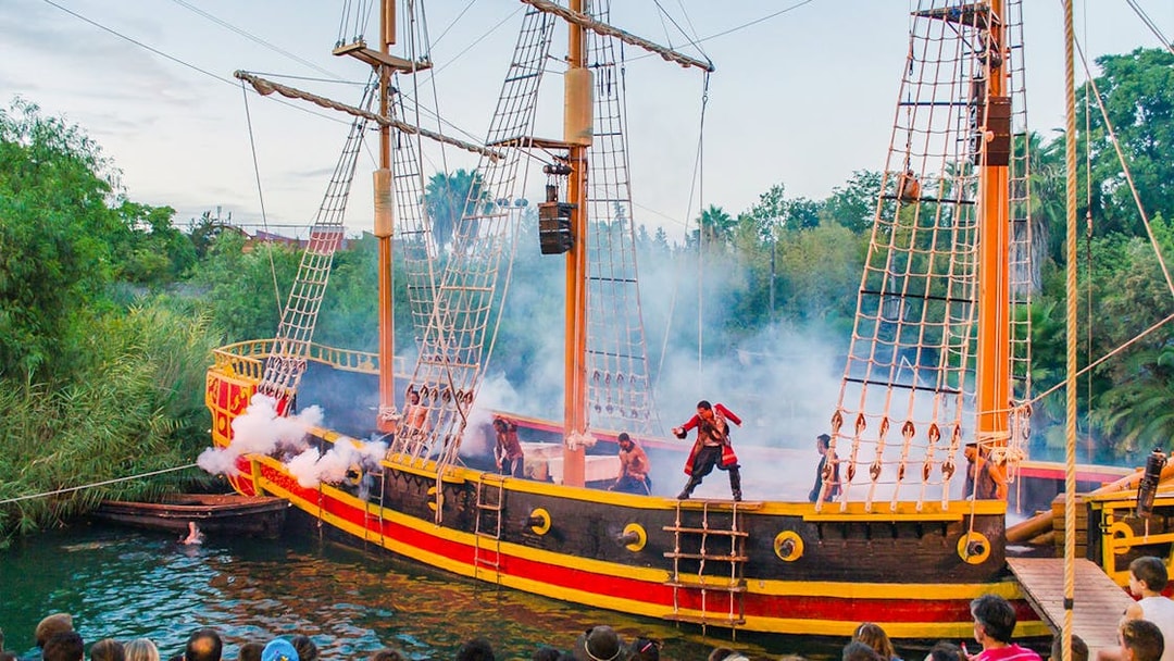 Pirate ship performance at Isla Magica with actors in costume and audience watching.