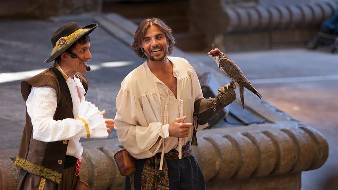 Falconry show at Isla Mágica with performers in period costumes.