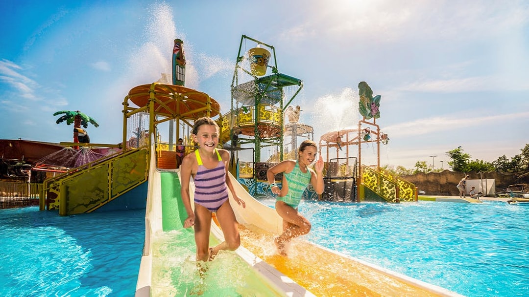 Children enjoying a water slide at Isla Mágica, Seville.