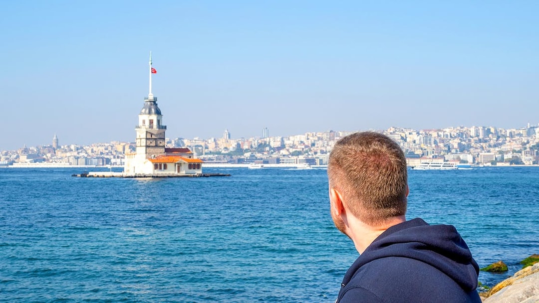Man viewing Maiden's Tower from Istanbul's Asian side during ferry tour.