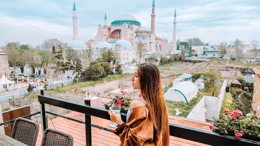 Woman enjoying view of Hagia Sophia from a terrace in Istanbul during a half-day walking tour.