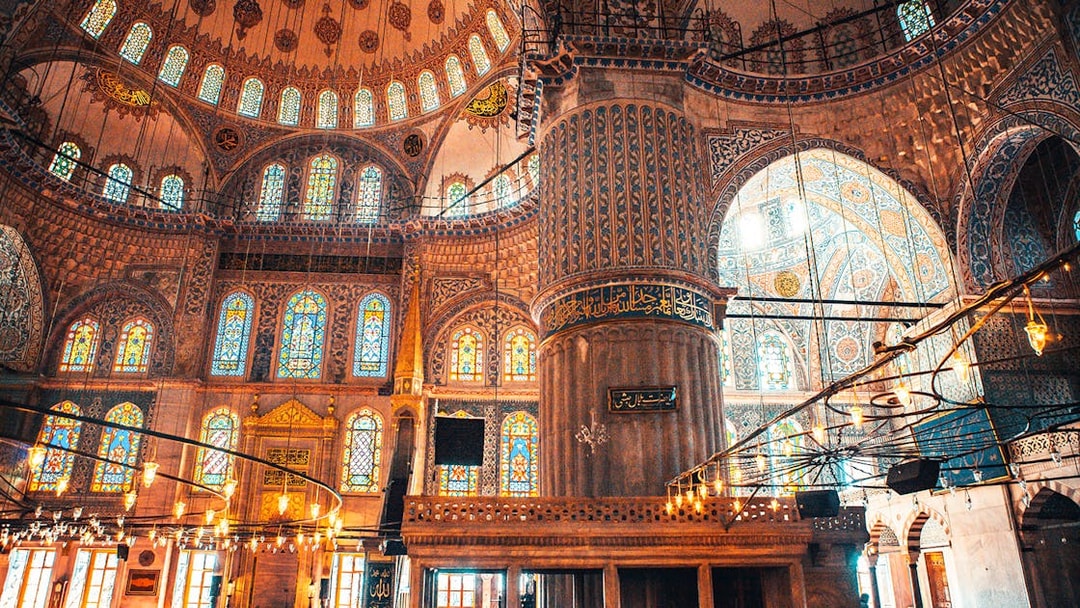 Interior of a mosque in Istanbul with ornate stained glass windows and intricate tile work.