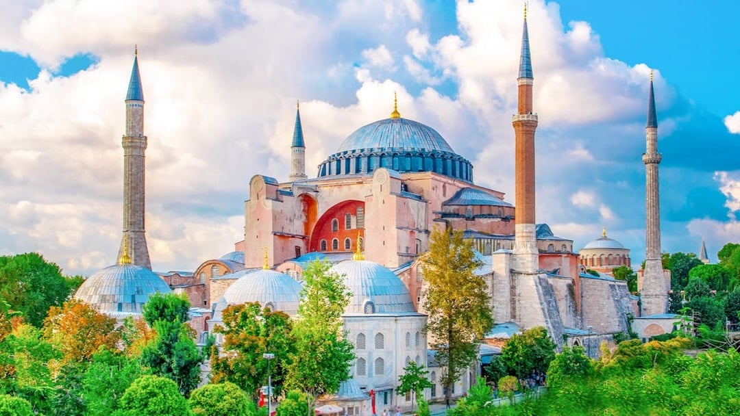 Hagia Sophia exterior with minarets in Istanbul, surrounded by greenery.