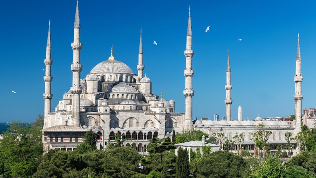Blue Mosque exterior with minarets in Istanbul, surrounded by greenery.