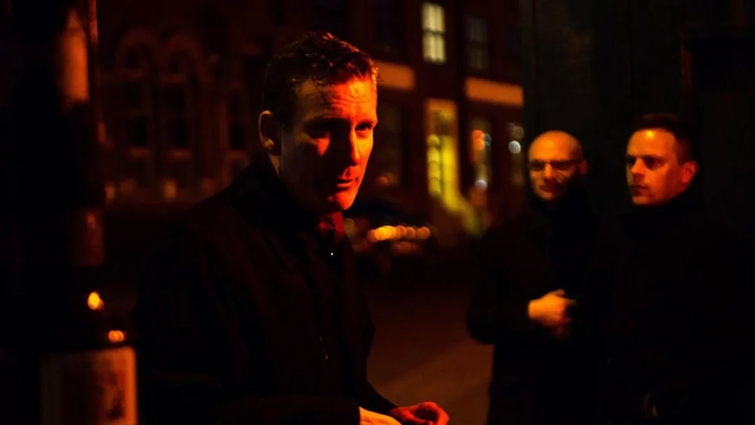 Tour guide leading Jack The Ripper & Haunted London Tour at night.