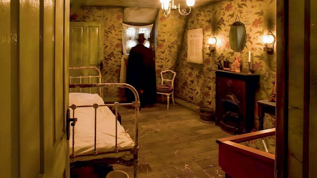 Victorian-style room in Jack the Ripper Museum with bed, fireplace, and figure by window.
