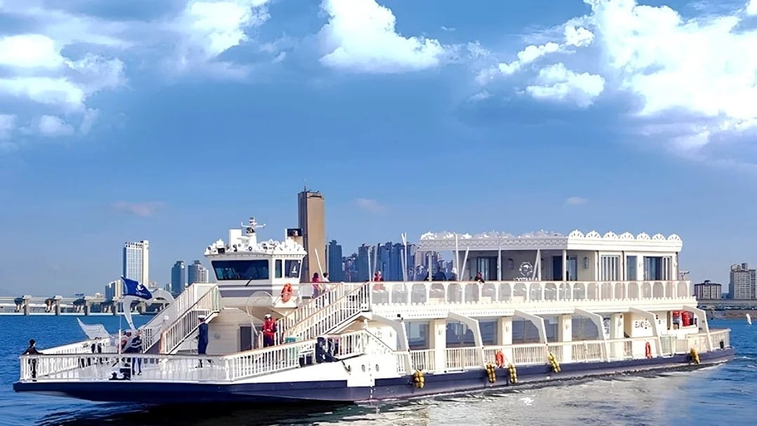 Cruise ship on Hangang River with Seoul skyline in the background.