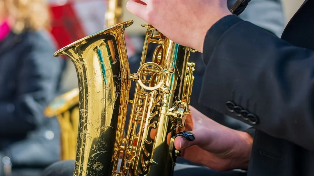Saxophonist playing on a lively street during a New Orleans day tour.