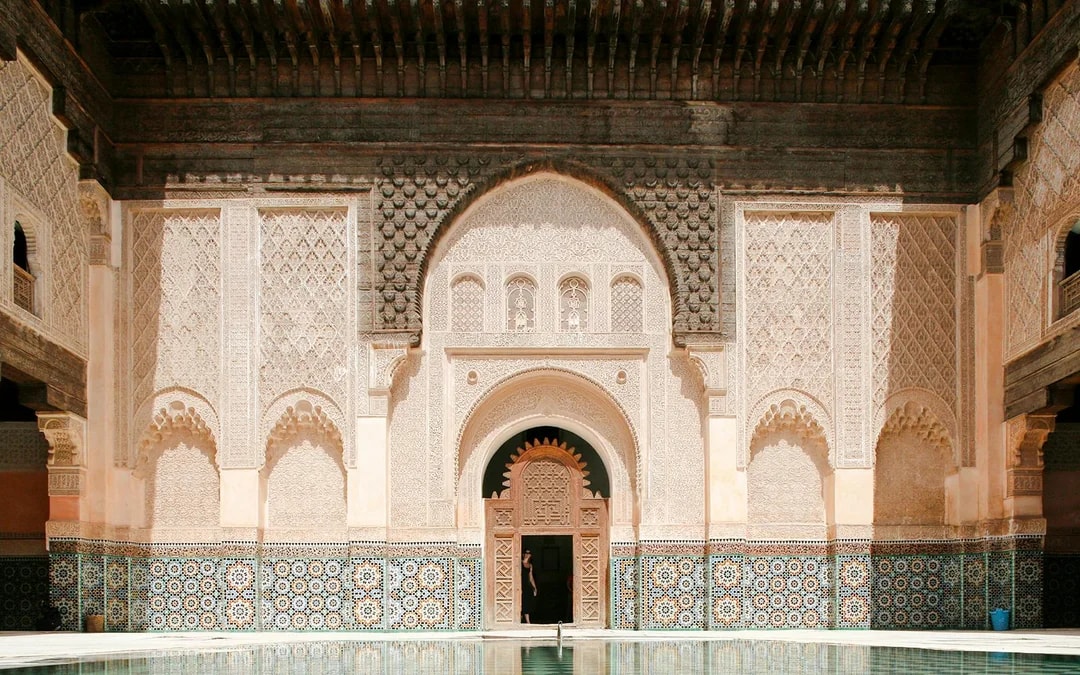 Ben Youssef Madrasa courtyard with intricate tilework and carved arches, Marrakesh, Morocco.