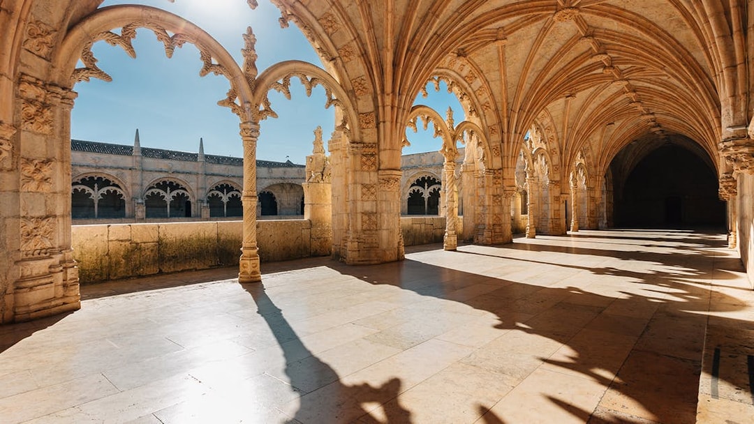 Gothic arches and stone columns inside Jerónimos Monastery, Lisbon.