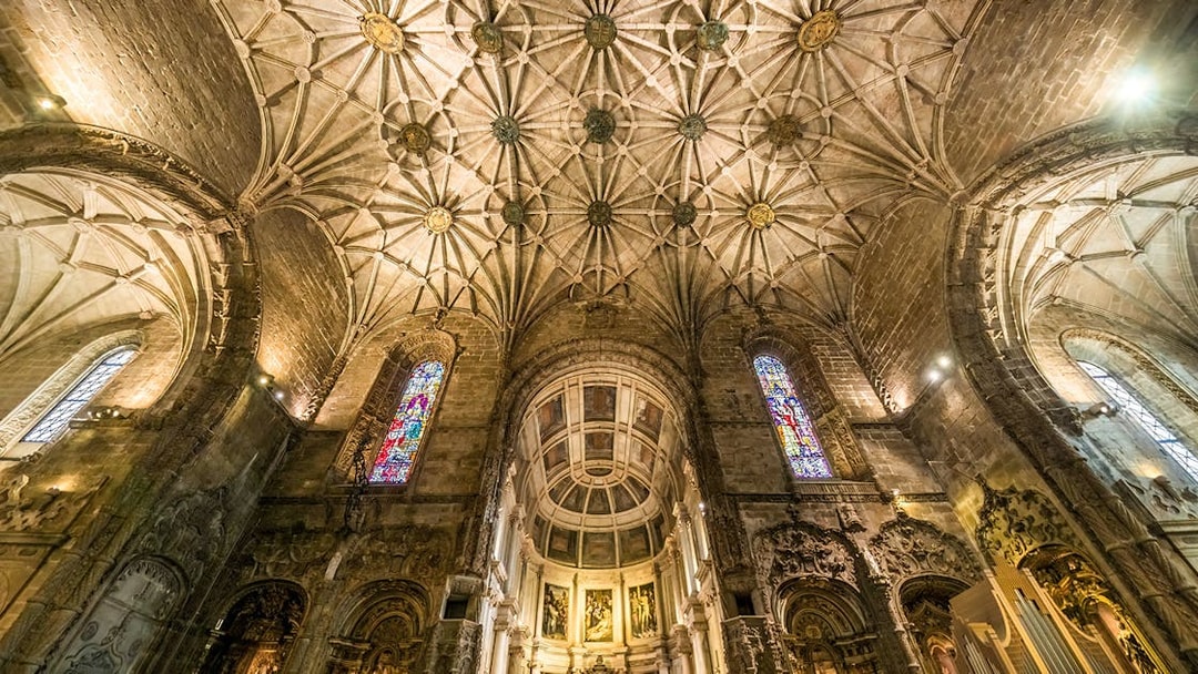 Jernimos Monastery interior with vaulted ceiling and stained glass windows in Lisbon, Portugal.