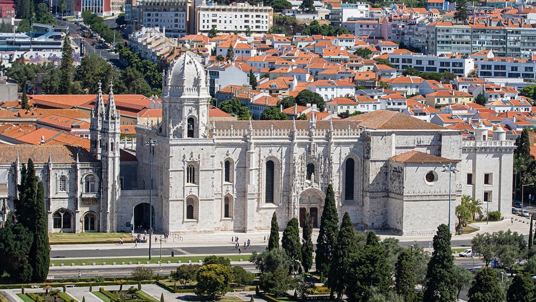Jerónimos Monastery in Lisbon with surrounding gardens and cityscape.