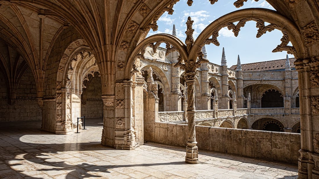 Jerónimos Monastery cloister with detailed arches and stone carvings in Lisbon, Portugal.