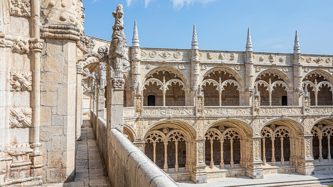 Jerónimos Monastery cloister with ornate arches and detailed stone carvings in Lisbon, Portugal.