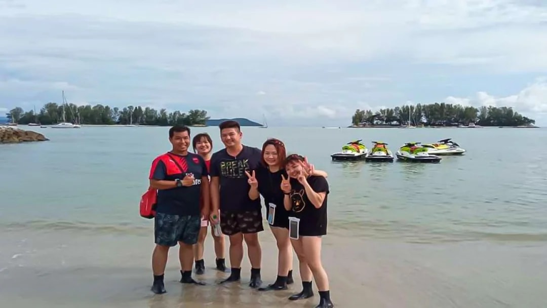 Group on beach with jet skis in Langkawi.