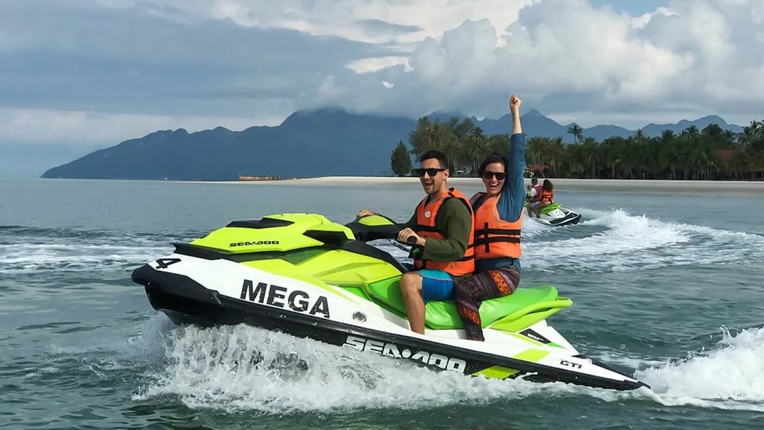 Jet skiing on Langkawi waters with lush mountains in the background.