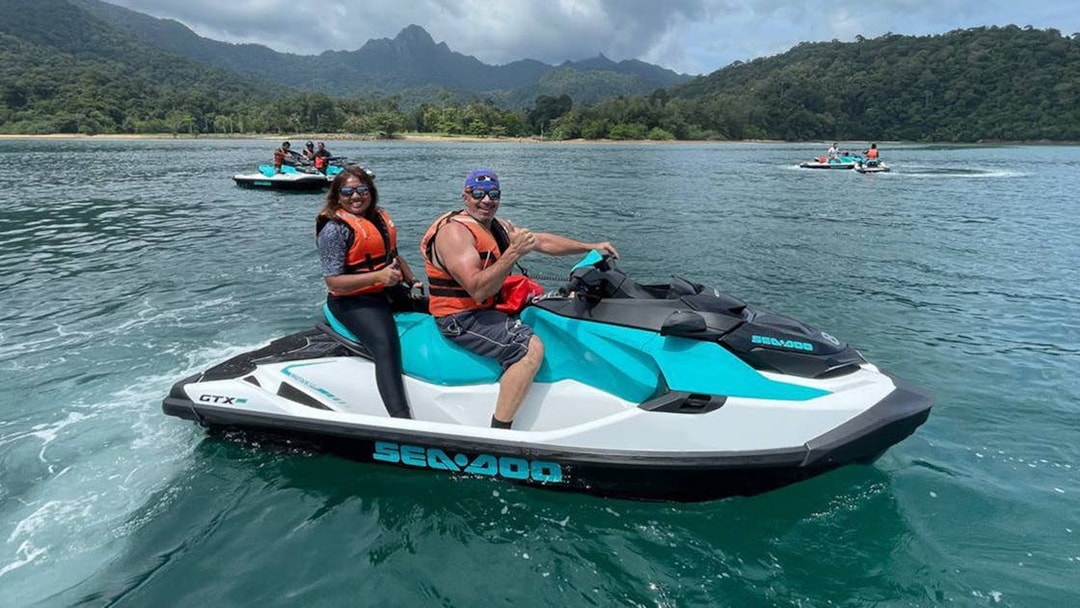 Jet skiing on turquoise waters with lush Langkawi hills in the background.