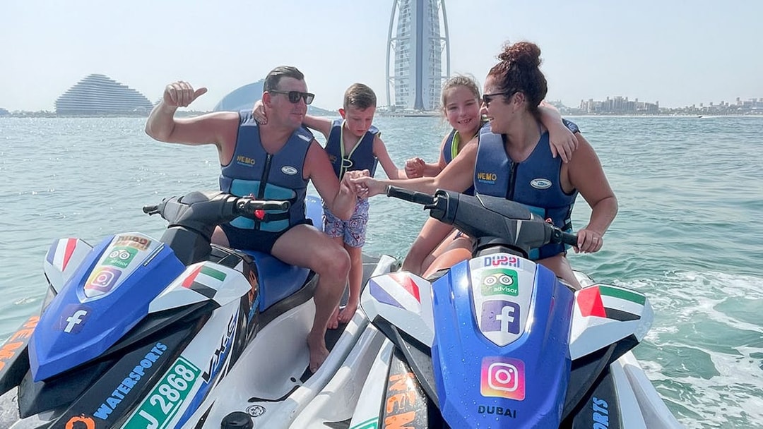 Family on jet skis near Burj Al Arab, Dubai.