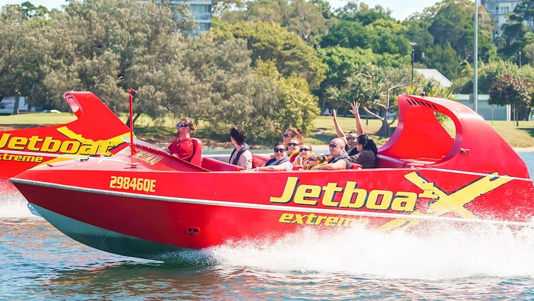 Jet boat with passengers enjoying a thrilling ride on the water.