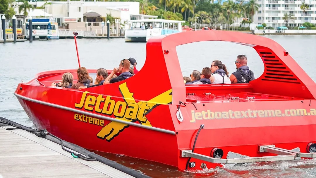 Jet boat with passengers departing dock for Ultimate Jet Boat Ride and Surf Lesson.