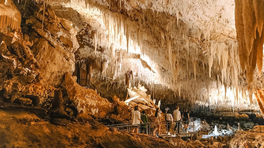 Visitors exploring stalactites in Jewel Cave, Margaret River guided tour.