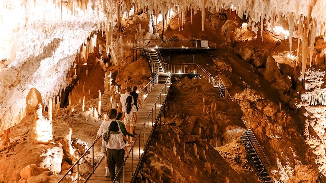Visitors exploring stalactites and stalagmites in Jewel Cave, Margaret River guided tour.