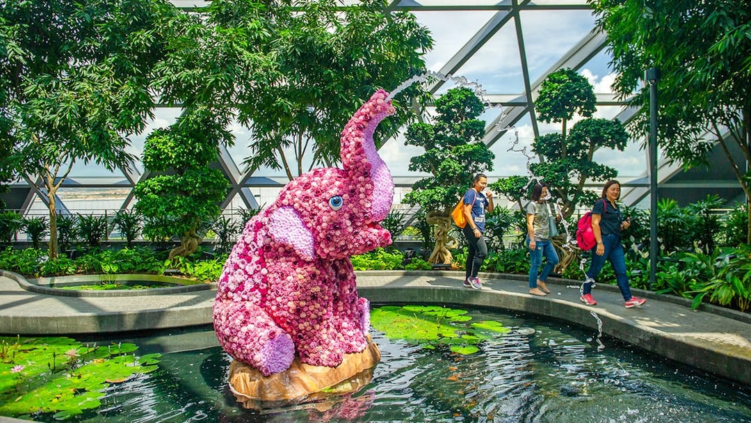 Topiary elephant sculpture in Canopy Park, Jewel Changi, with visitors walking nearby.