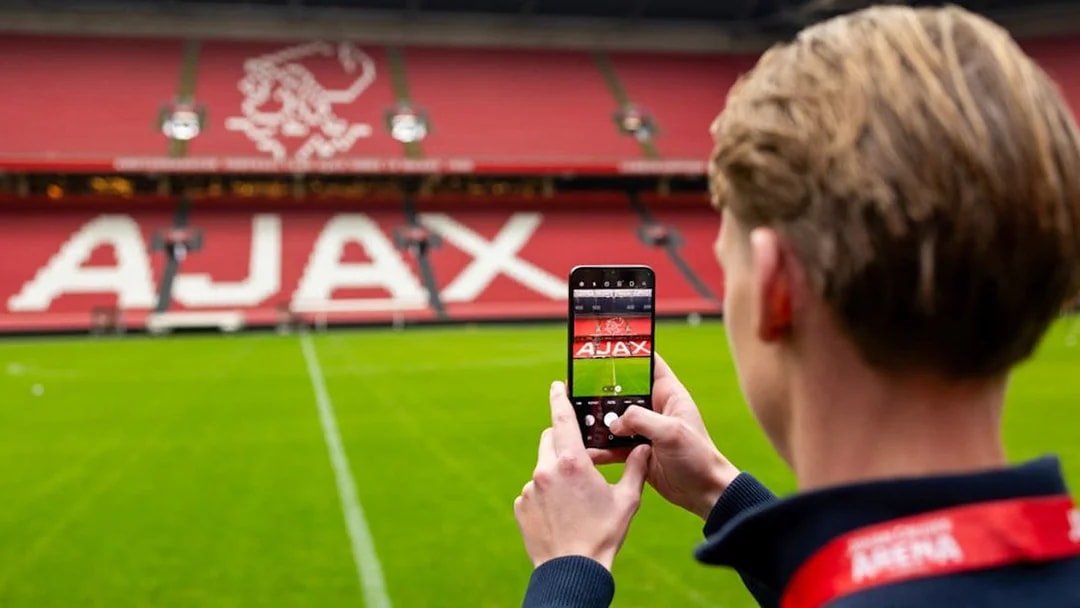 Person photographing Ajax stadium interior during Johan Cruijff ArenA Classic Tour.