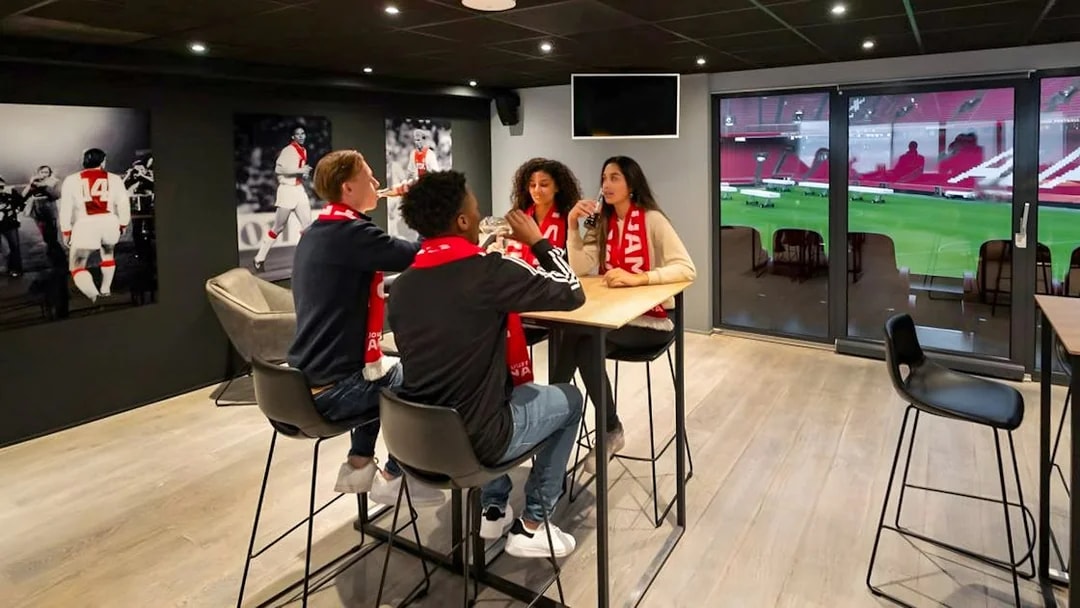 Visitors enjoying drinks and a view of the field during a VIP tour at Johan Cruijff ArenA, Amsterdam.