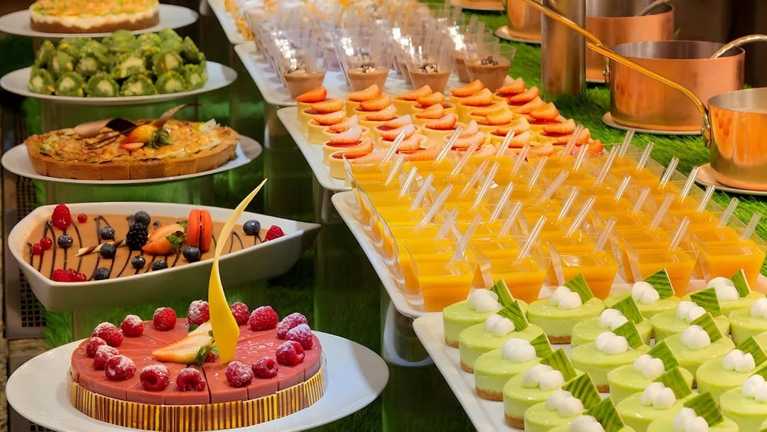 Dessert selection at Kaleidoscope buffet, Atlantis Dubai, featuring cakes and fruit tarts.