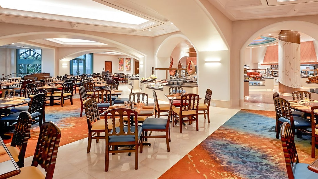 Seating area in Kaleidoscope restaurant, Atlantis Dubai, with colorful decor and dining tables.