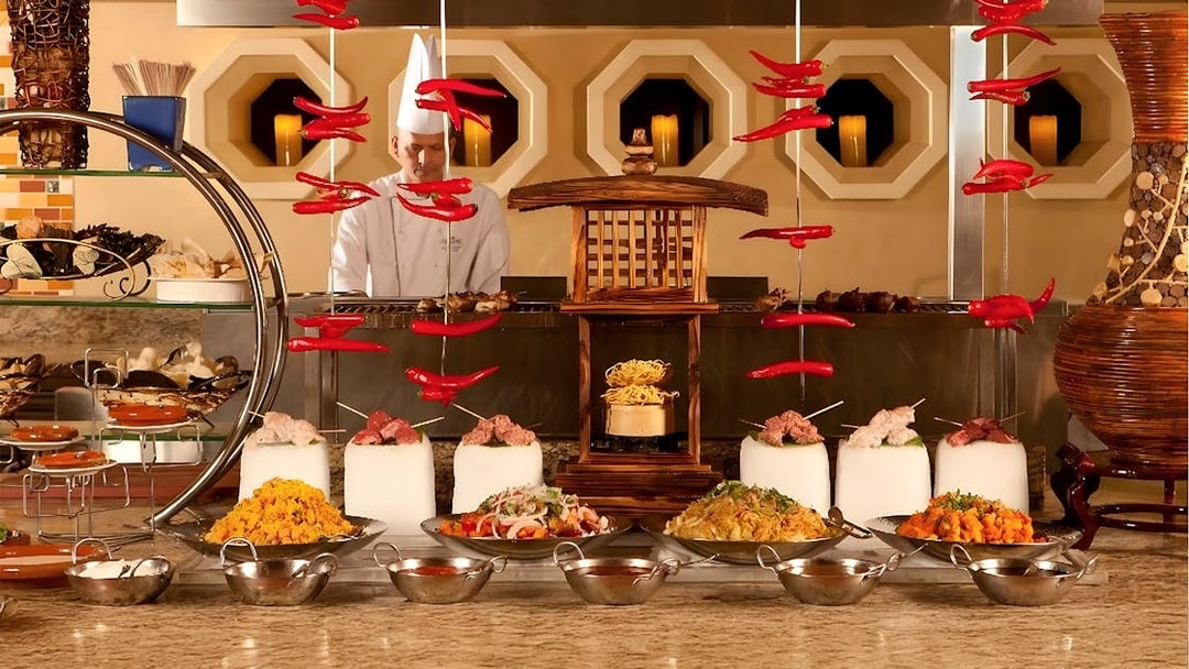Live kitchen display at Buffet Kaleidoscope Atlantis Dubai with chef and diverse dishes.