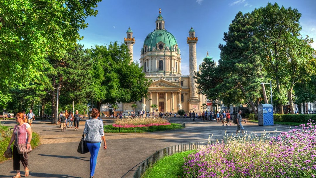 Karlskirche in Vienna with people walking in the garden, location for Vivaldi’s Four Seasons concert.