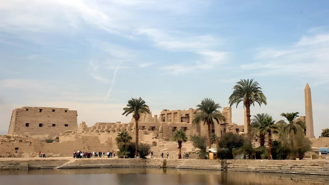 Karnak Temple complex with palm trees and obelisk, Luxor, Egypt.