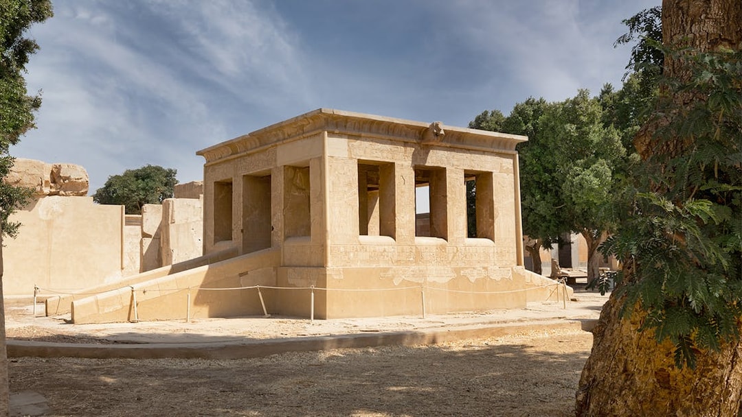 Karnak Temple ruins with hieroglyphs, surrounded by trees, Luxor, Egypt.