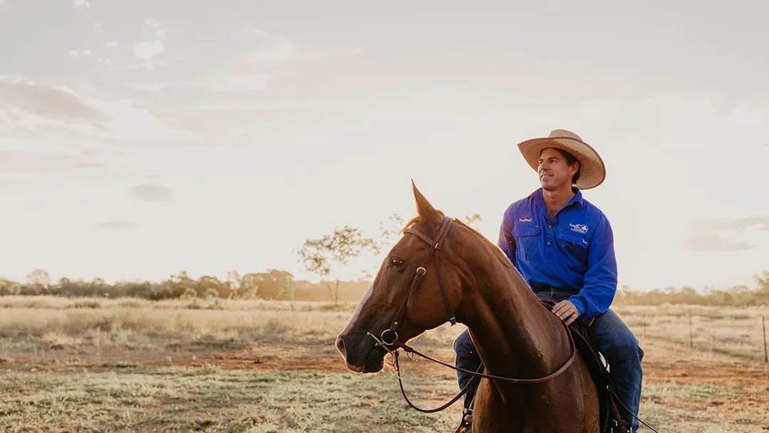 Horse rider in blue shirt at Katherine Outback Experience, Australia.