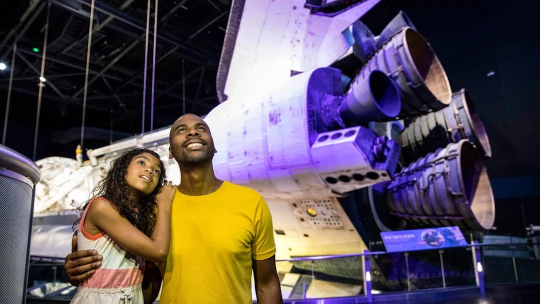 Visitors admiring a space shuttle at Kennedy Space Center.