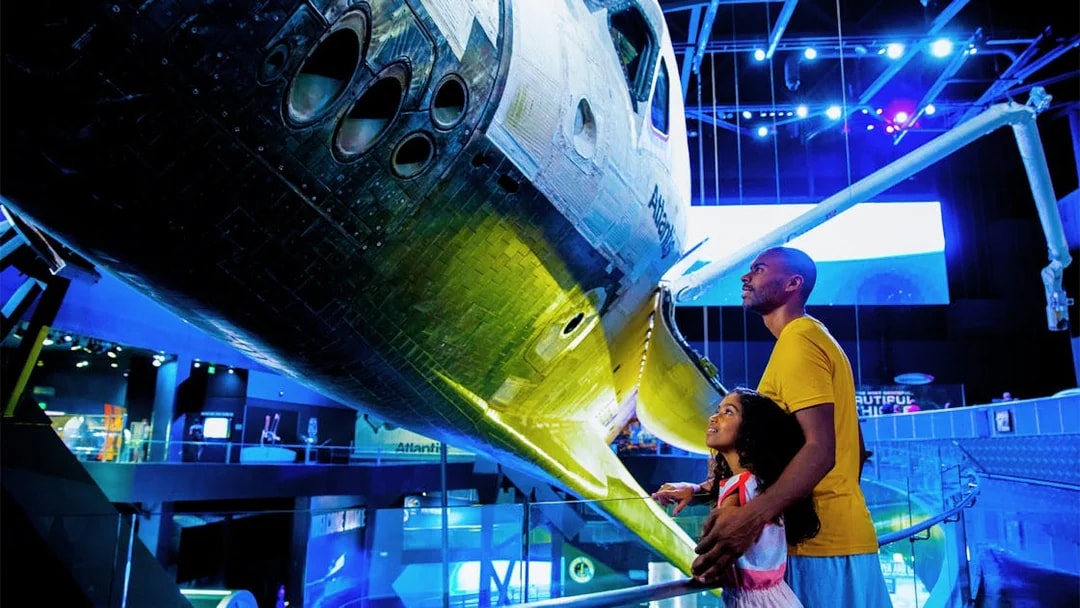 Visitors admiring space shuttle Atlantis at Kennedy Space Center.