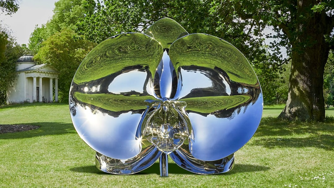 Reflective sculpture "Light of Life" by Marc Quinn in a park setting.
