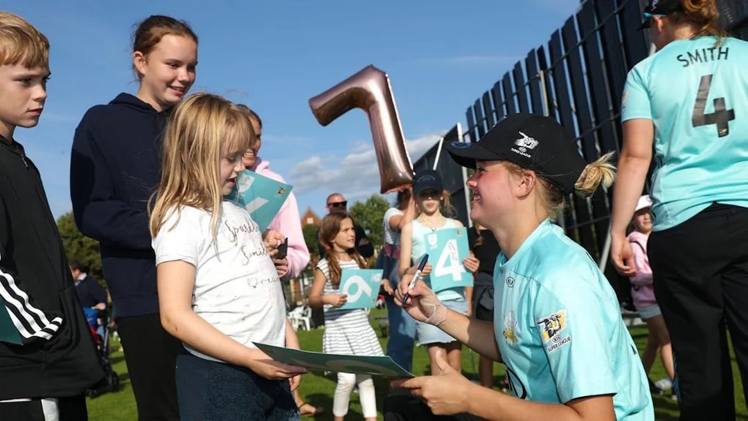 Cricketer signing autographs for children at Kia Oval Grounds tour.