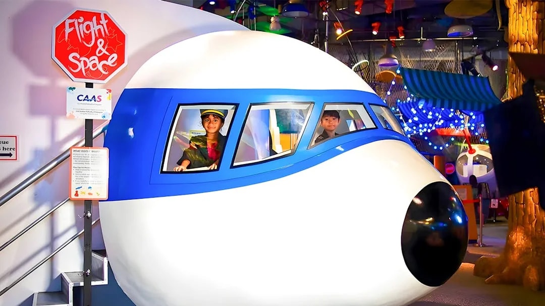 Children in a flight simulator at KidsSTOP Singapore.