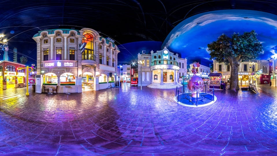 Kidzania Dubai indoor cityscape with illuminated buildings and activity areas.