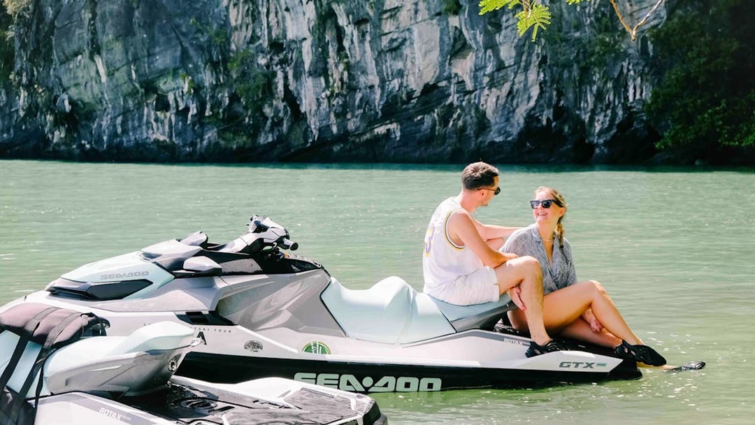 Jet ski on water with two people at Langkawi's UNESCO Kilim Geopark.