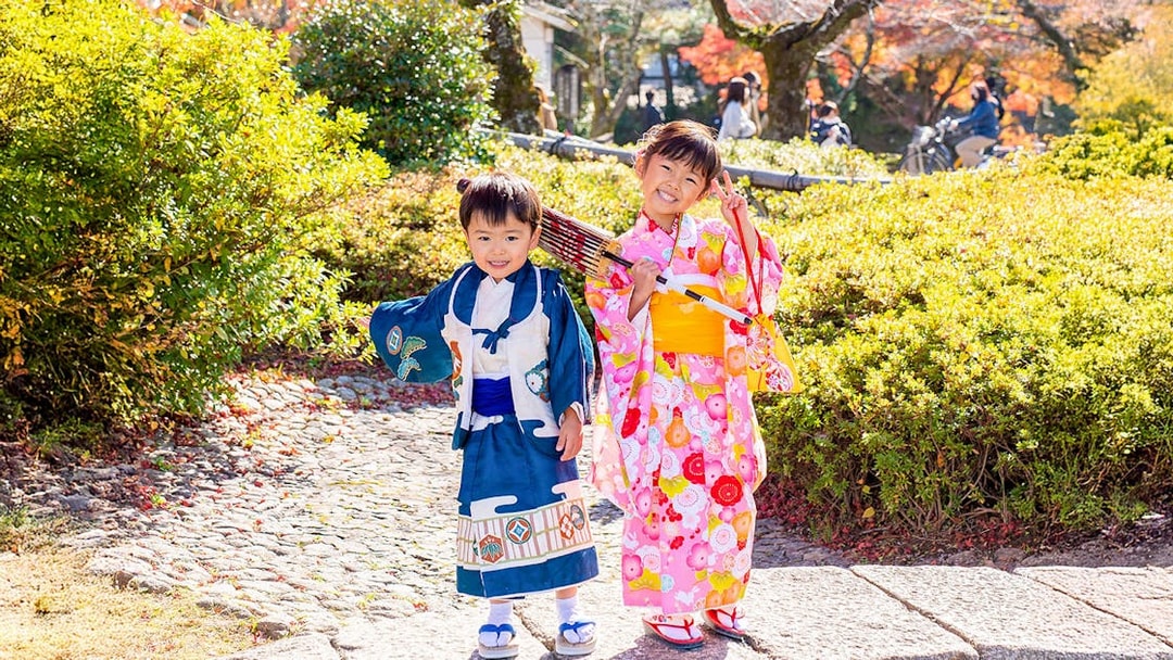 Kids in traditional kimono in Kyoto Arashiyama garden.