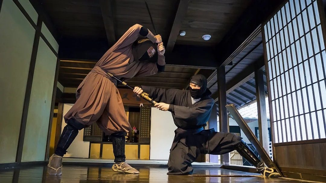 Ninjas demonstrating sword skills in a traditional Japanese dojo, Kintetsu Rail Pass.