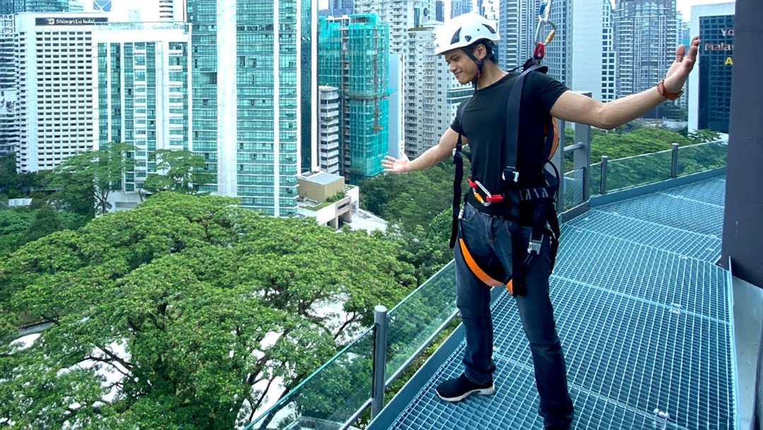 Person enjoying the KL Tower observation deck with Kuala Lumpur cityscape in the background.