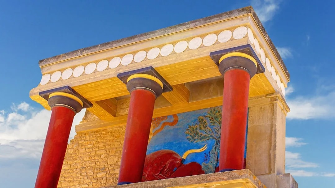 Knossos Palace fresco and red columns under blue sky, Crete, Greece.
