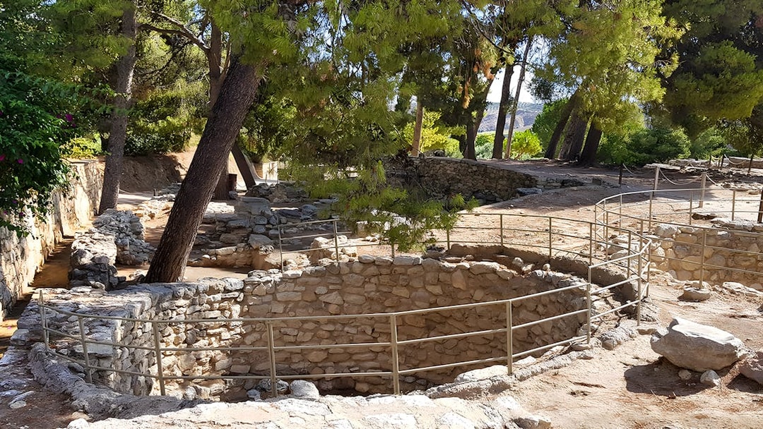 Ancient stone structures and trees in the yard of Knossos Palace, Crete.